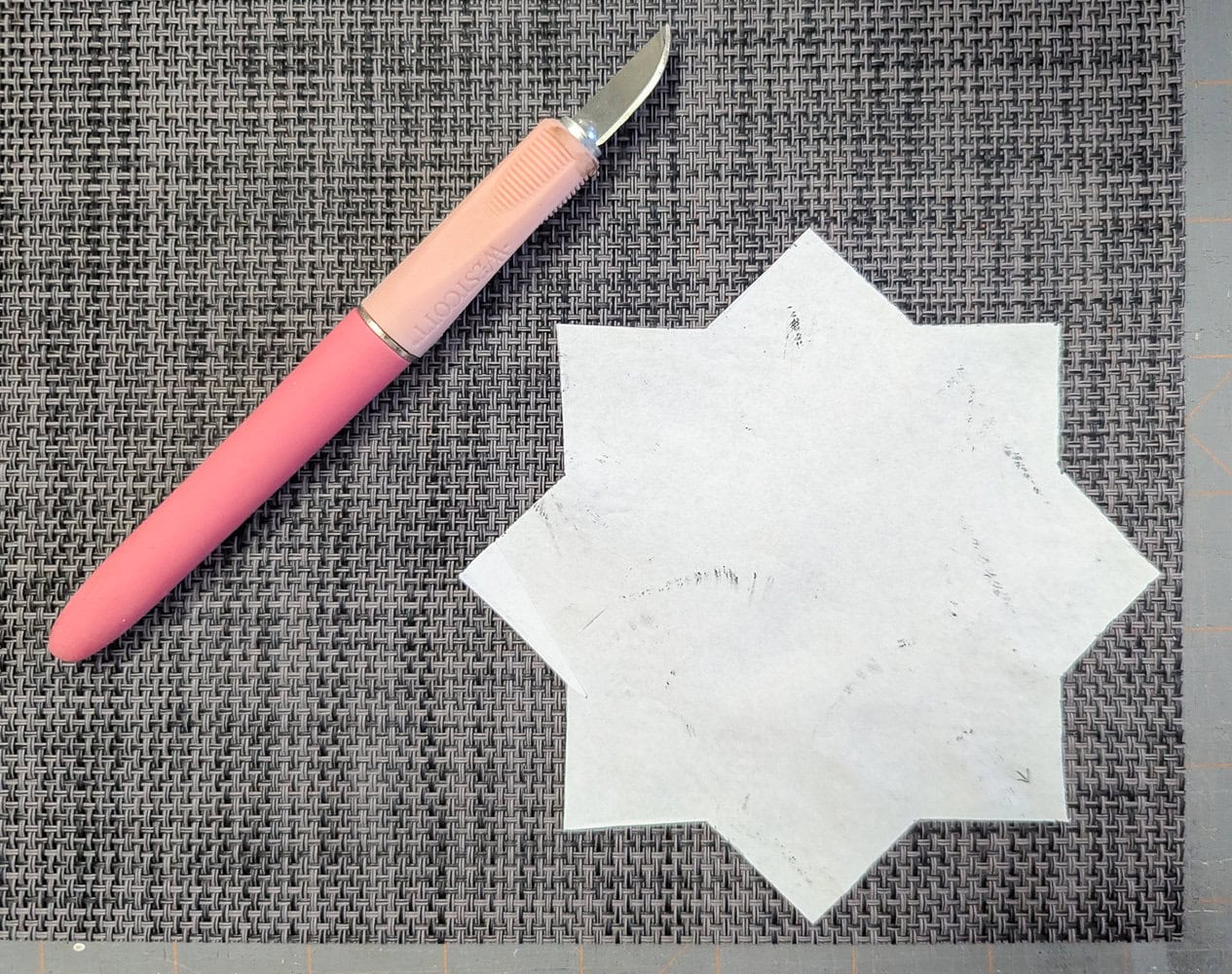 using a craft knife to cut placemat to the needed shape.