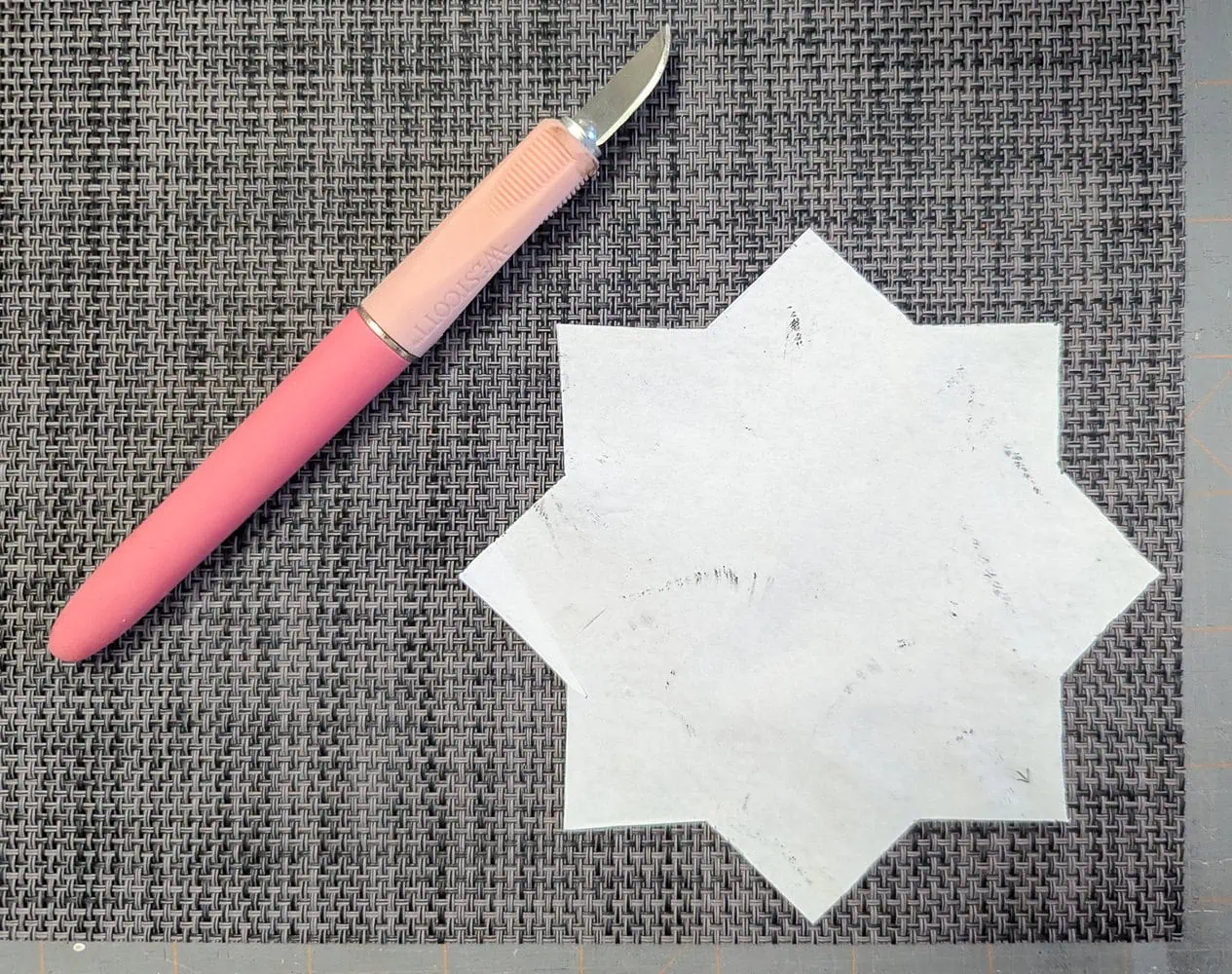 using a craft knife to cut placemat to the needed shape.