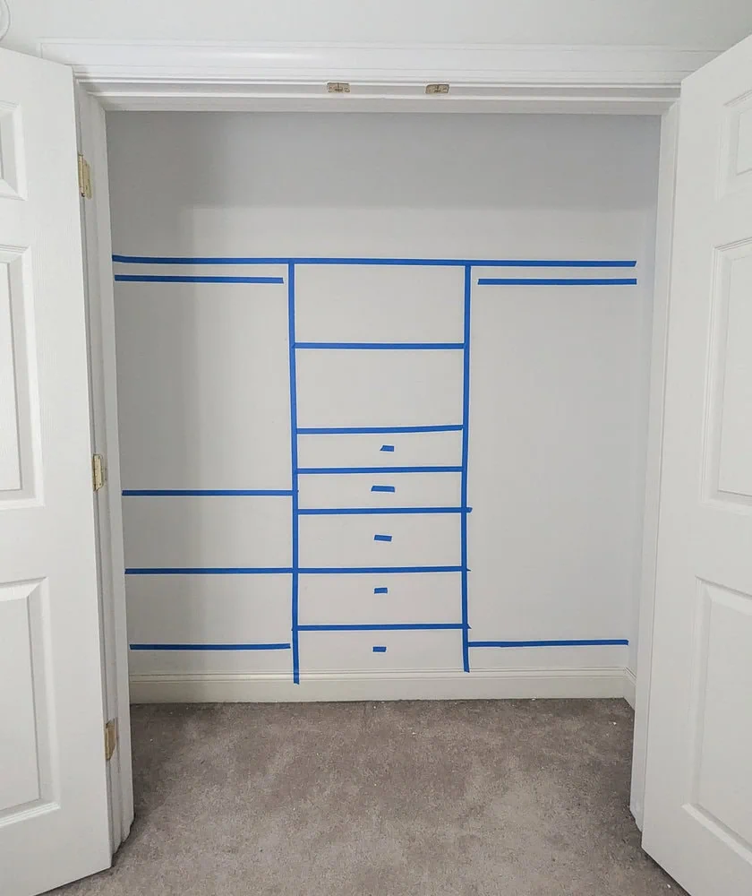 closet with shelves and drawers outlined on wall in painter's tape