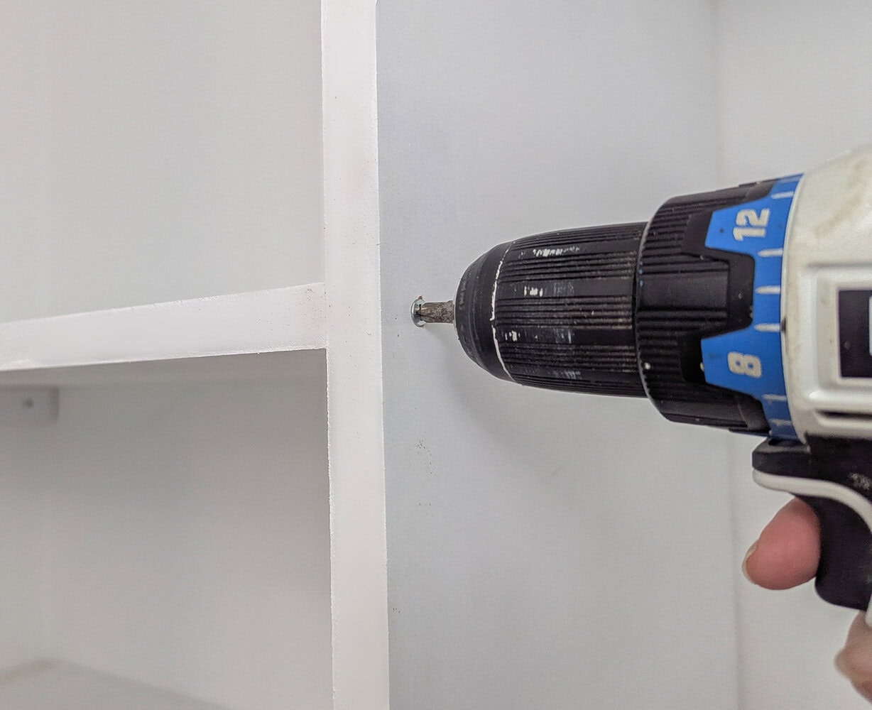 attaching shelves to vertical supports with screws.