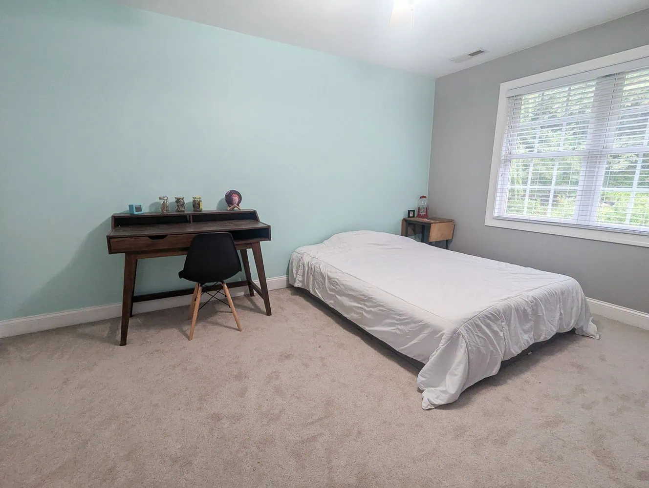 bedroom with mattress on floor and blank walls.