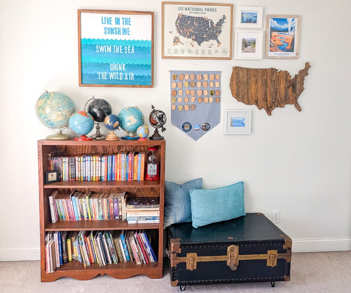 travel themed gallery wall above vintage globe collection and bench made from an old trunk.