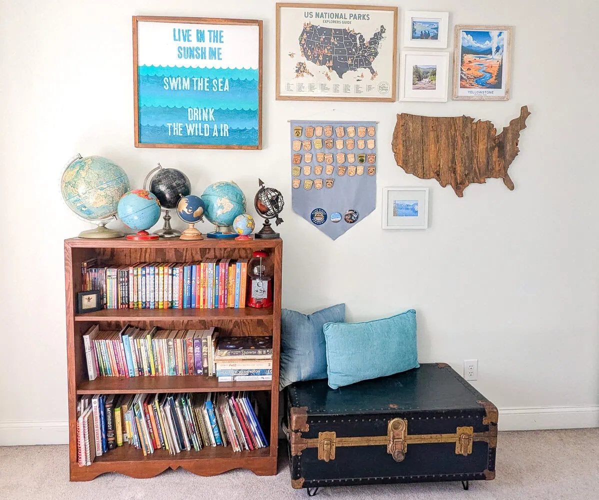travel themed gallery wall above vintage globe collection and bench made from an old trunk.