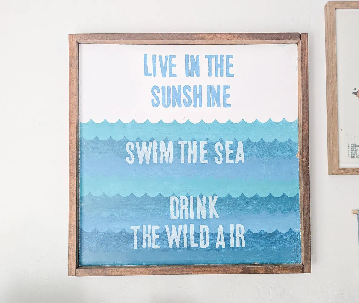 diy wooden sign that says Live in the sunshine, swim the sea, drink the wild air.