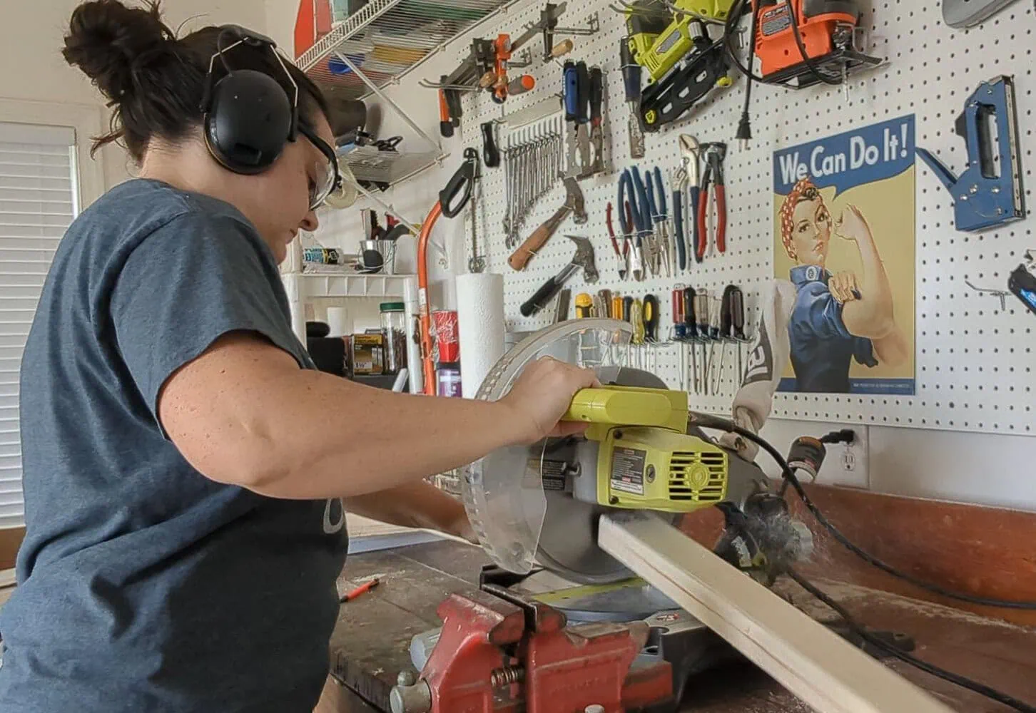 cutting wood with a miter saw in workshop.