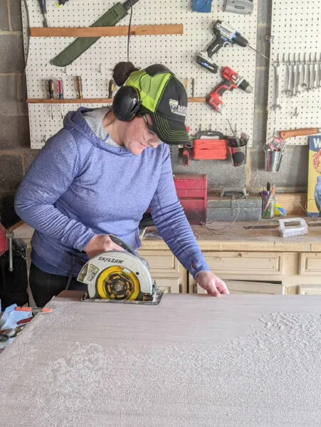lady cutting plywood with a circular saw.