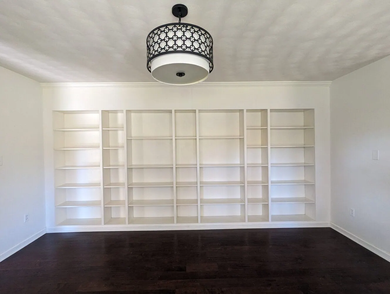 wall of built in bookshelves made using IKEA billy bookcases.