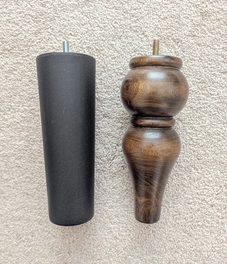 black plastic bed leg next to turned wood bed leg.