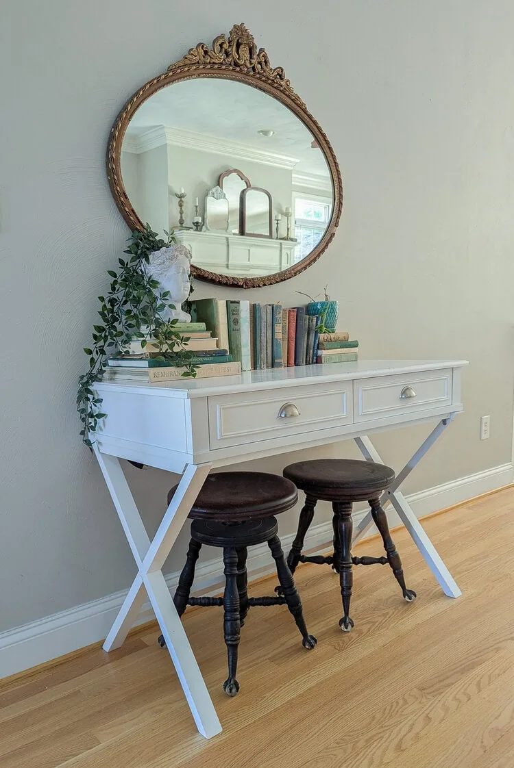 white writing desk with gold antique mirror and brushed nickel hardware.
