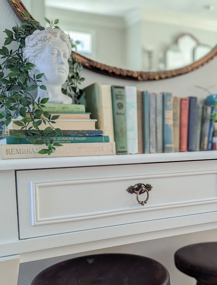 close up of aged brass hardware on white desk.