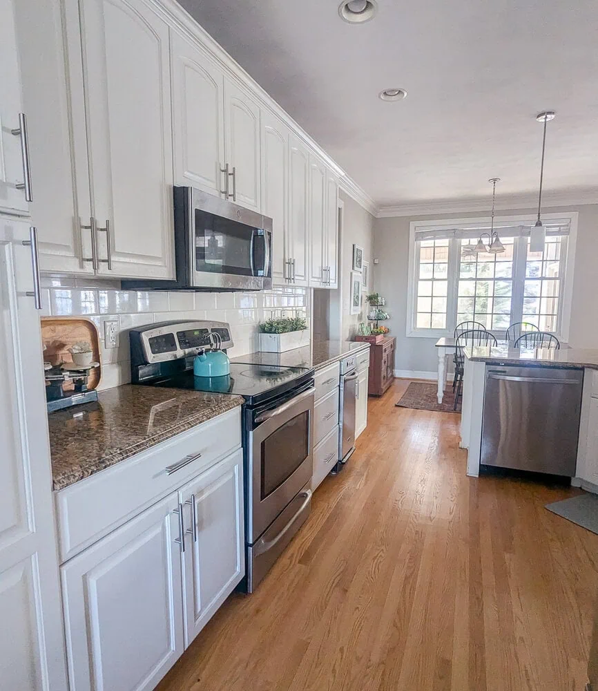 kitchen with white cabinets and wood floors.