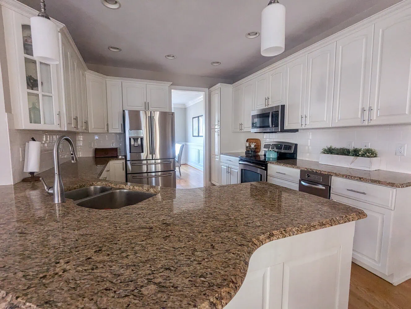 white kitchen with brown speckled granite.