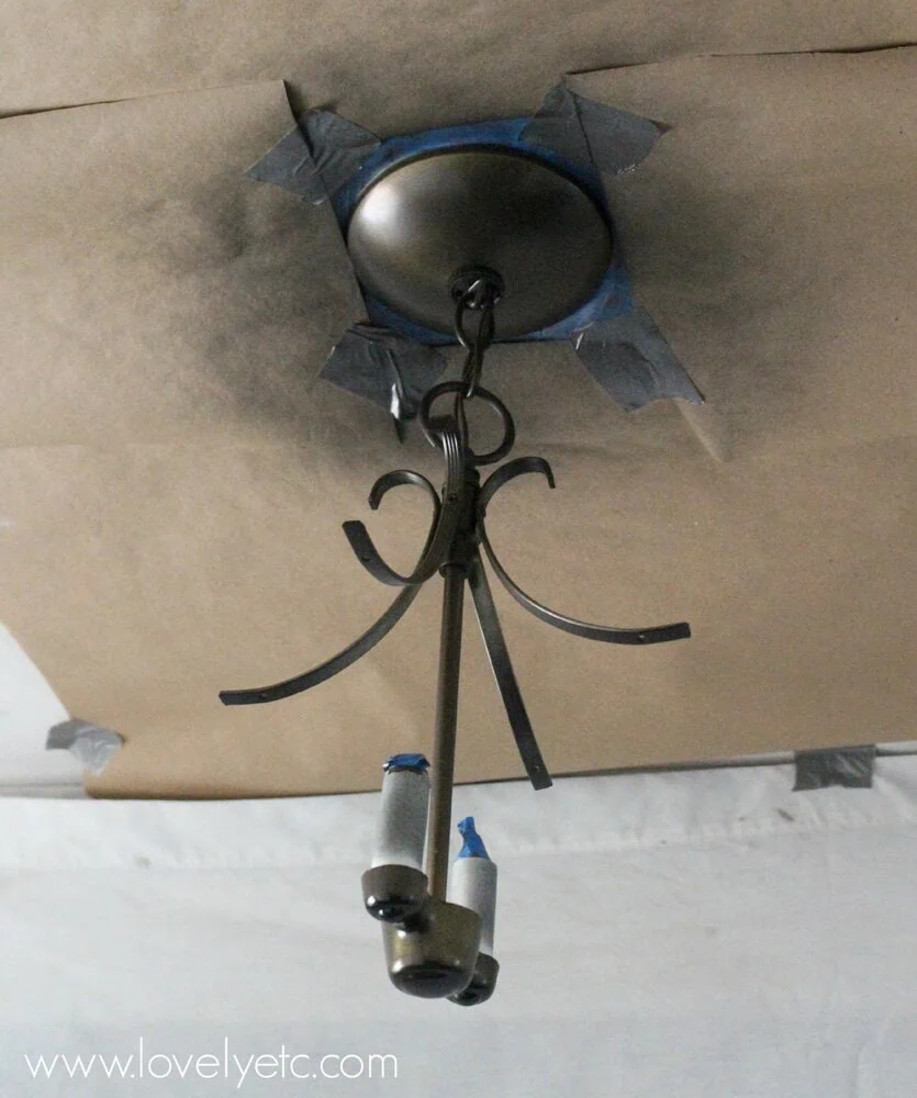 spray painting a light fixture.