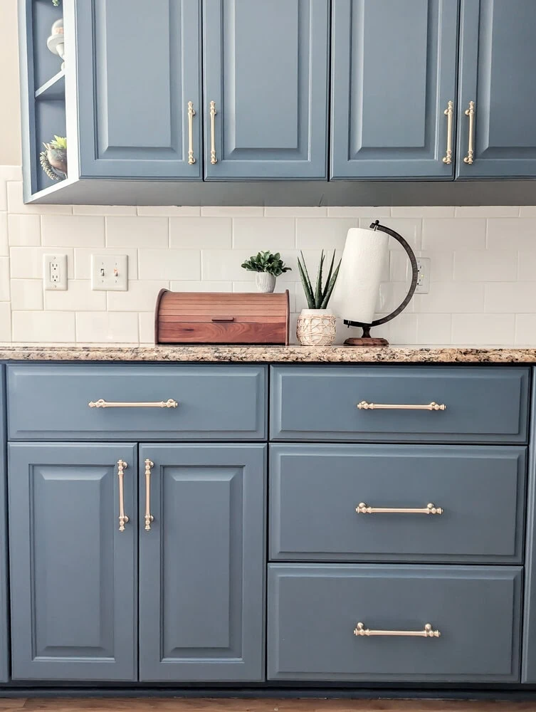 Deep blue kitchen cabinets with brushed brass hardware.