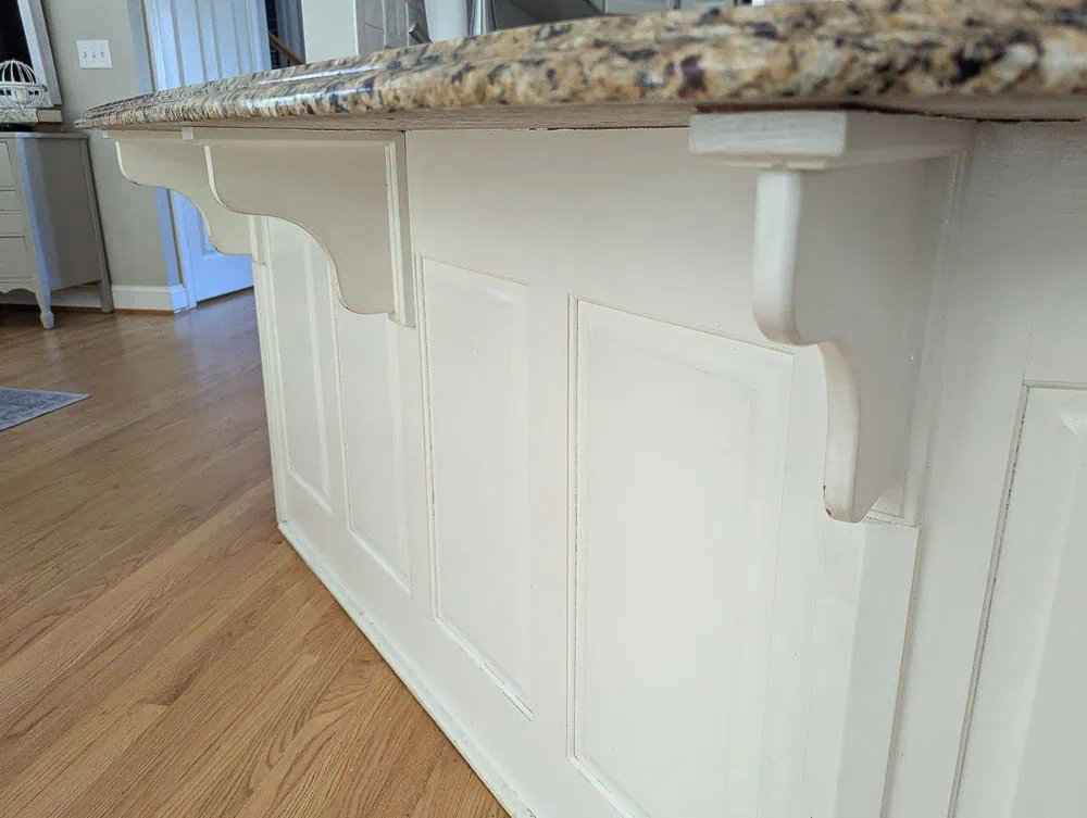 Kitchen peninsula with curvy corbels supporting countertop.