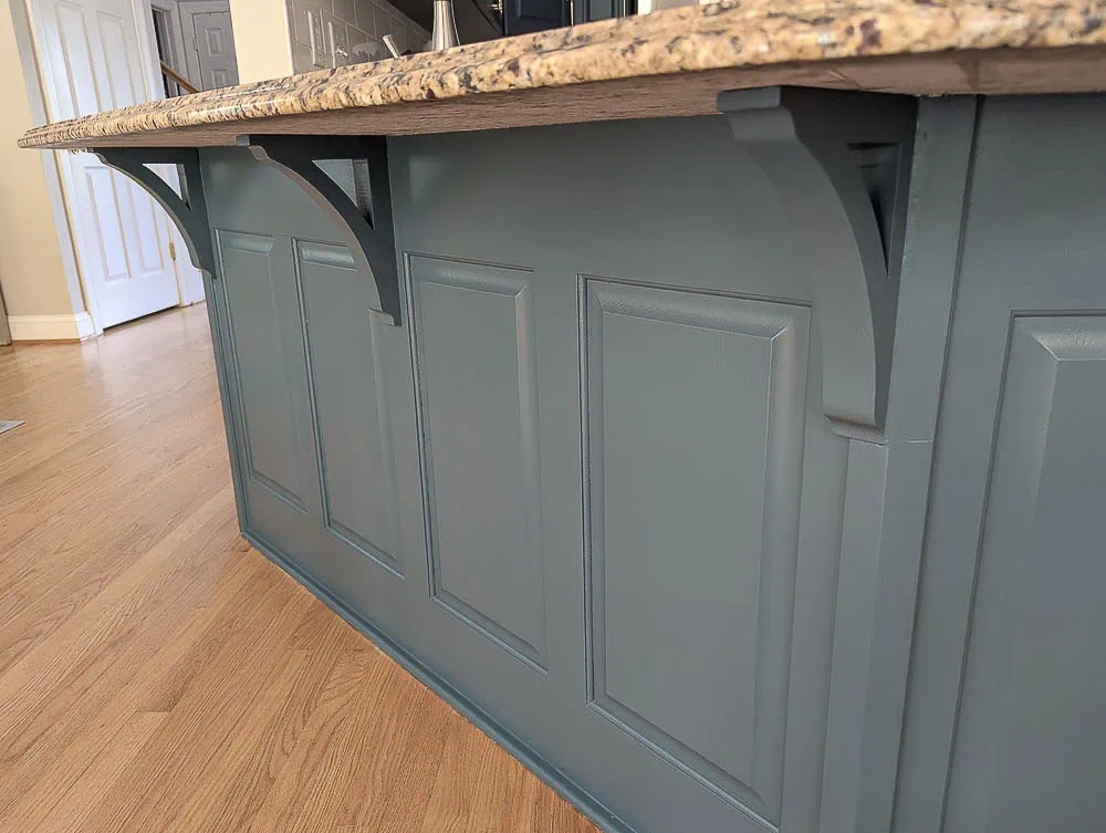Kitchen peninsula with updated wood corbels supporting countertop.
