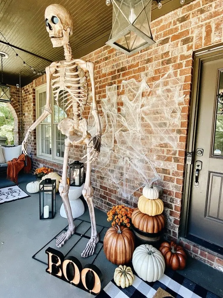 large skeleton hanging on front porch for Halloween