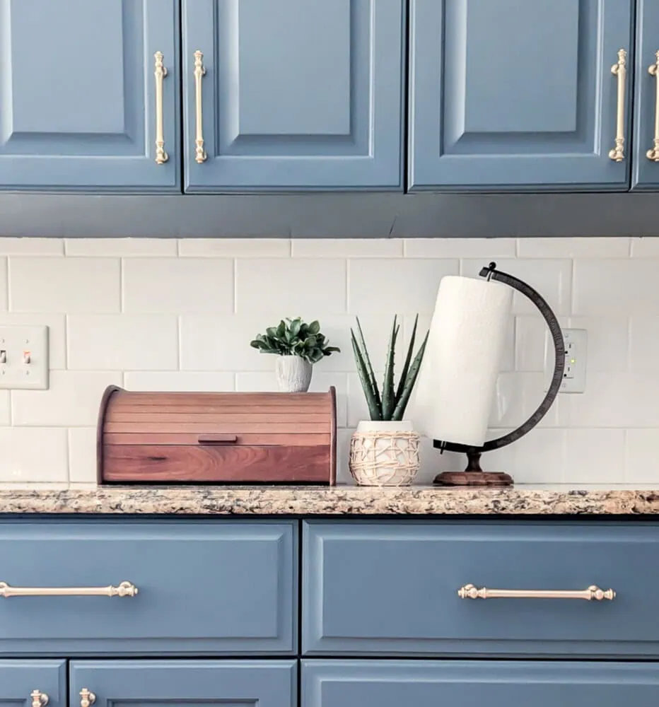 paper towel holder made from an old globe stand next to wooden bread box.
