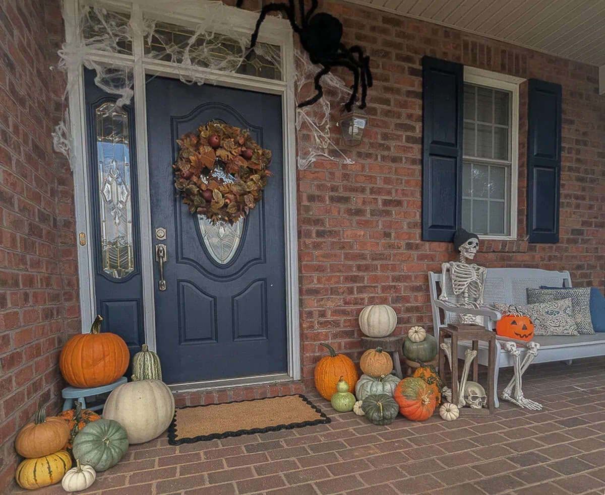 Brick front porch decorated for Halloween.