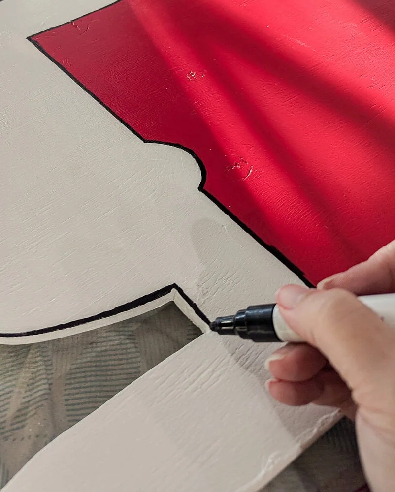 using a paint marker to outline the edges of Snoopy.